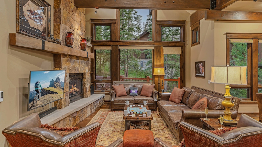 Great room on main level with gas fireplace, TV, and deck access