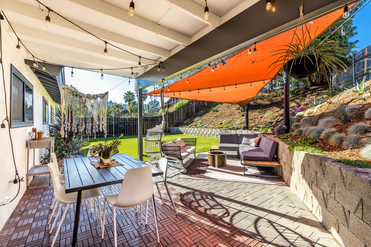 Private backyard patio with covered dining table and chairs