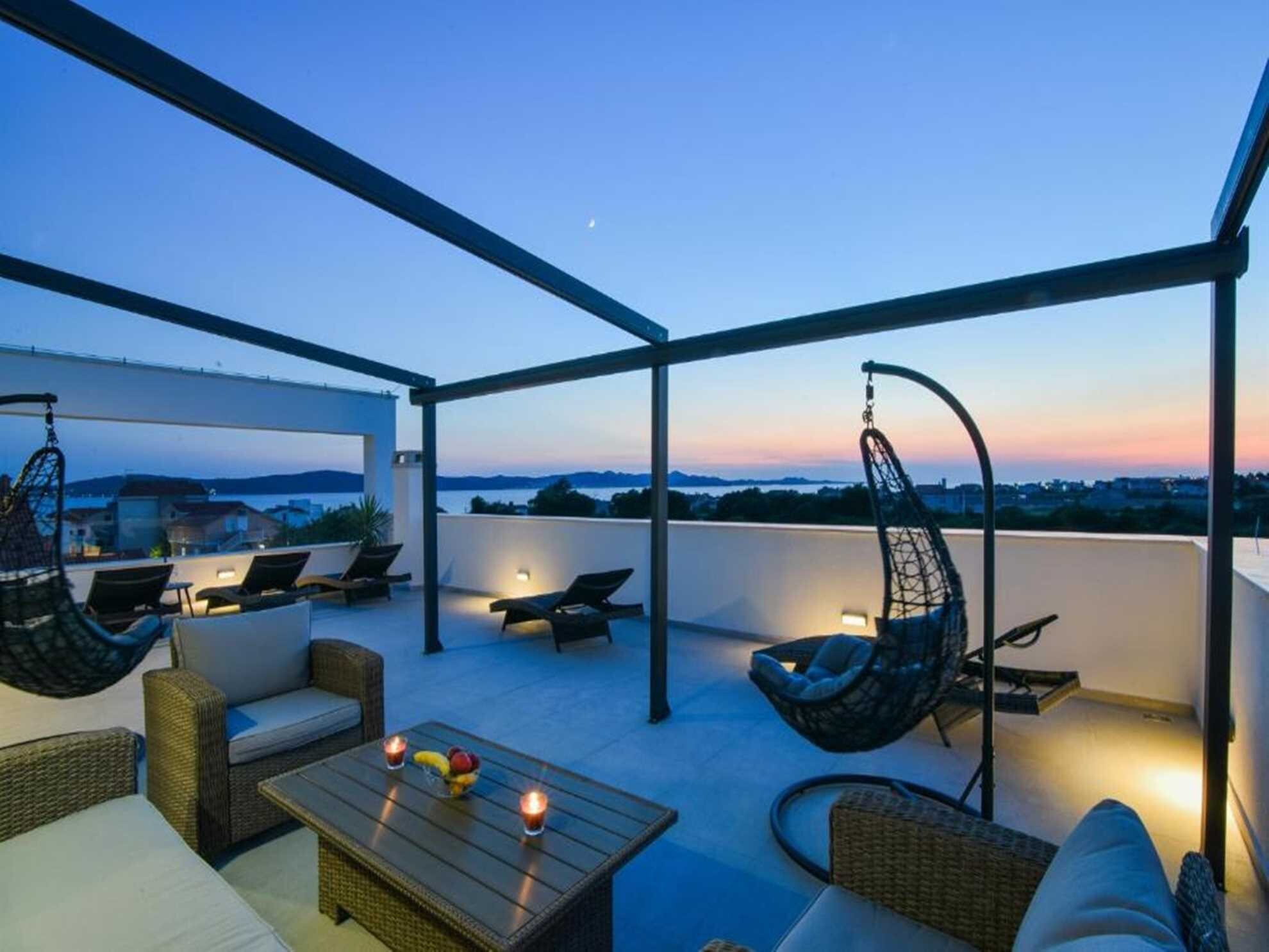 rooftop terrace with sundeck chairs and heated swimming pool 