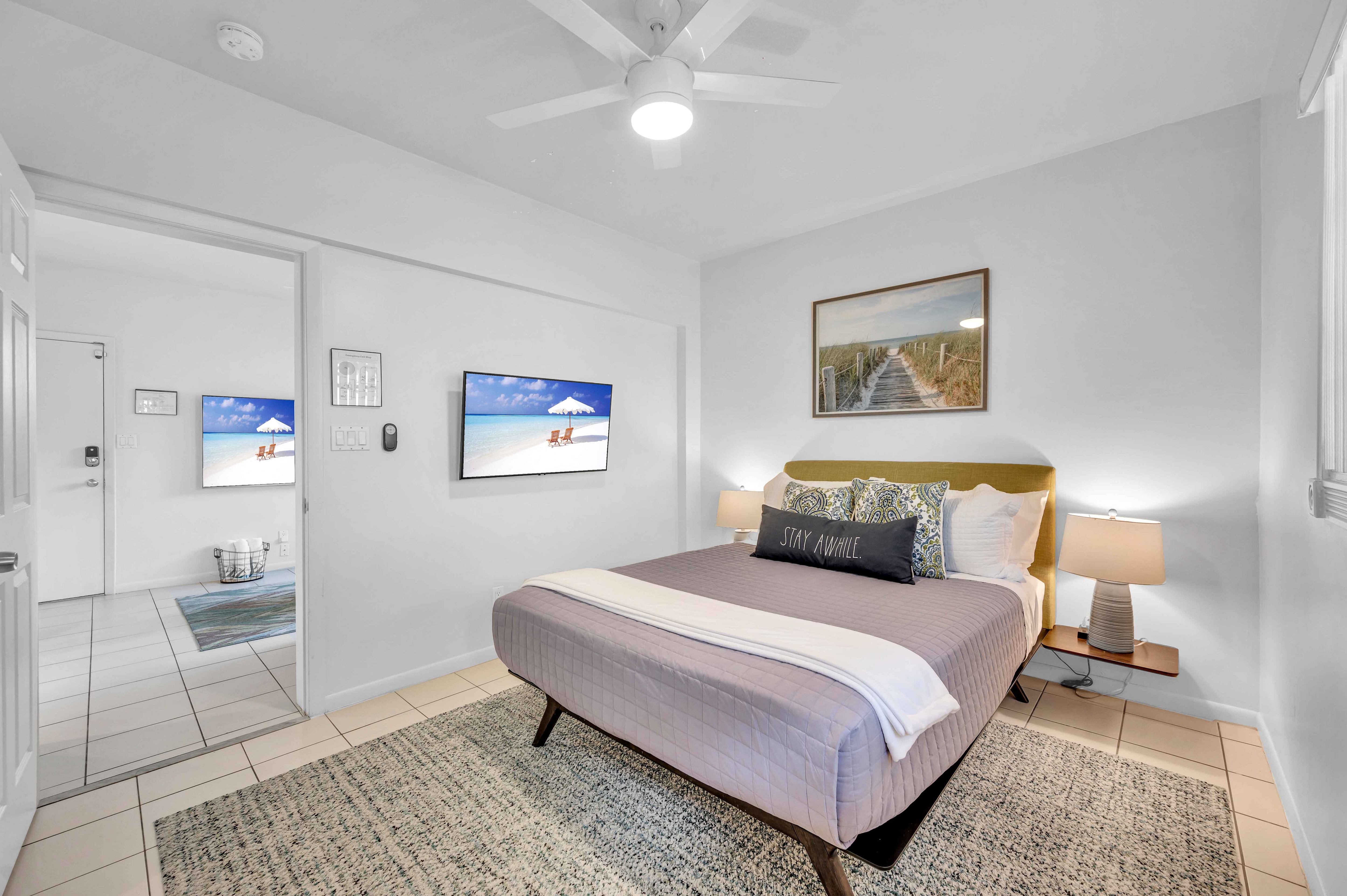 The bedroom features a king-sized bed and a wall-mounted Smart TV.