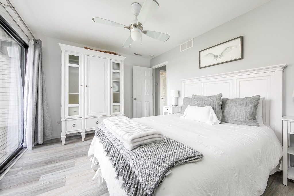 The master room boasts a flat-screen TV, a cabinet, a balcony, a ceiling fan, a wardrobe, and a king-size bed, creating a luxurious and comfortable space.