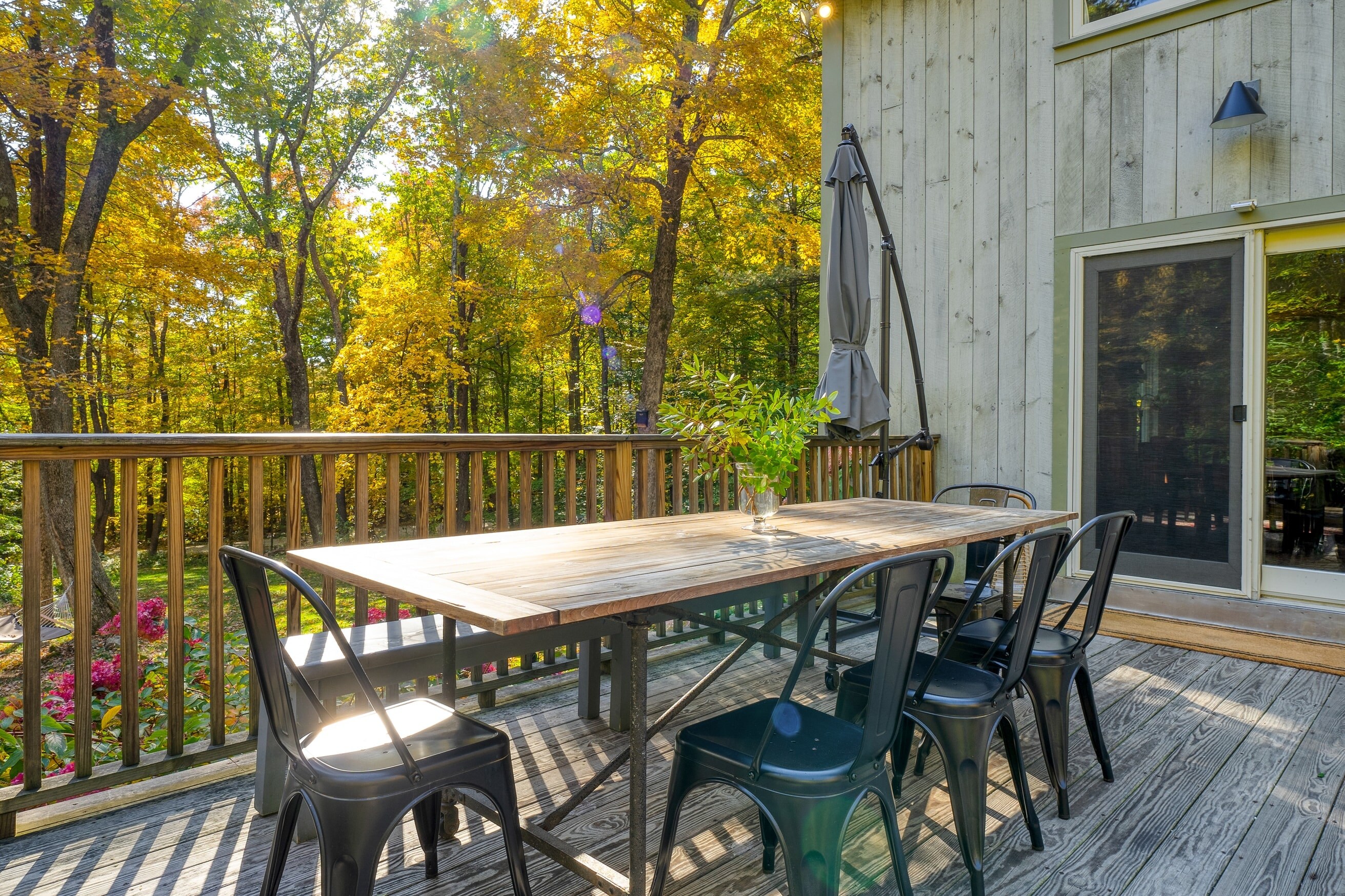 Large deck with an outdoor dining table, seating, and BBQ/grill.