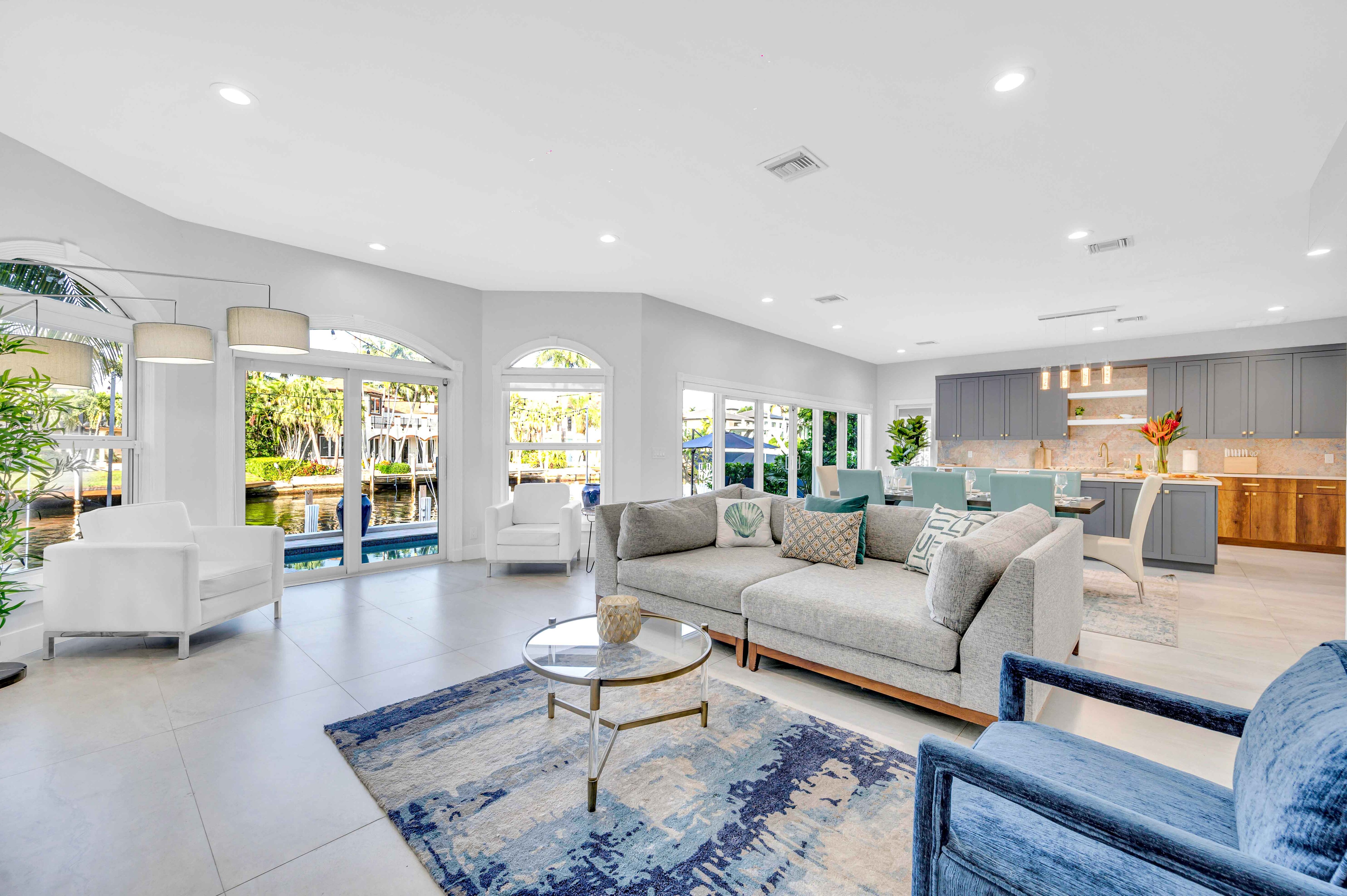 The open floor family room with the kitchen and dinning table offers a view of the waterfront and the heated swimming pool.
