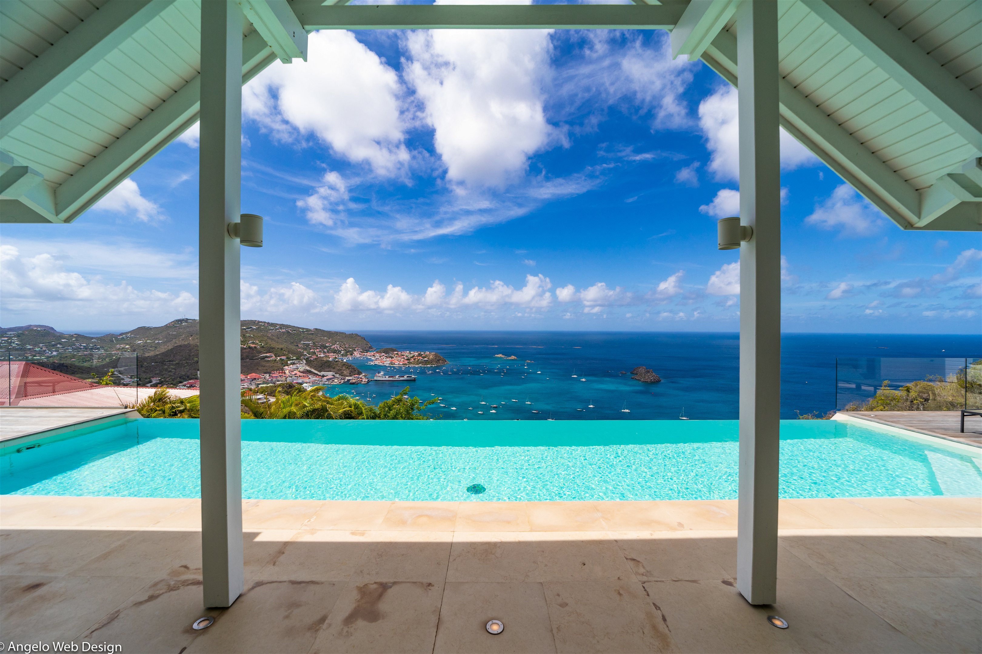 Magnificent heated pool facing the view, expansive terrace with loungers and deck chairs. Lounge area on the covered terrace. 