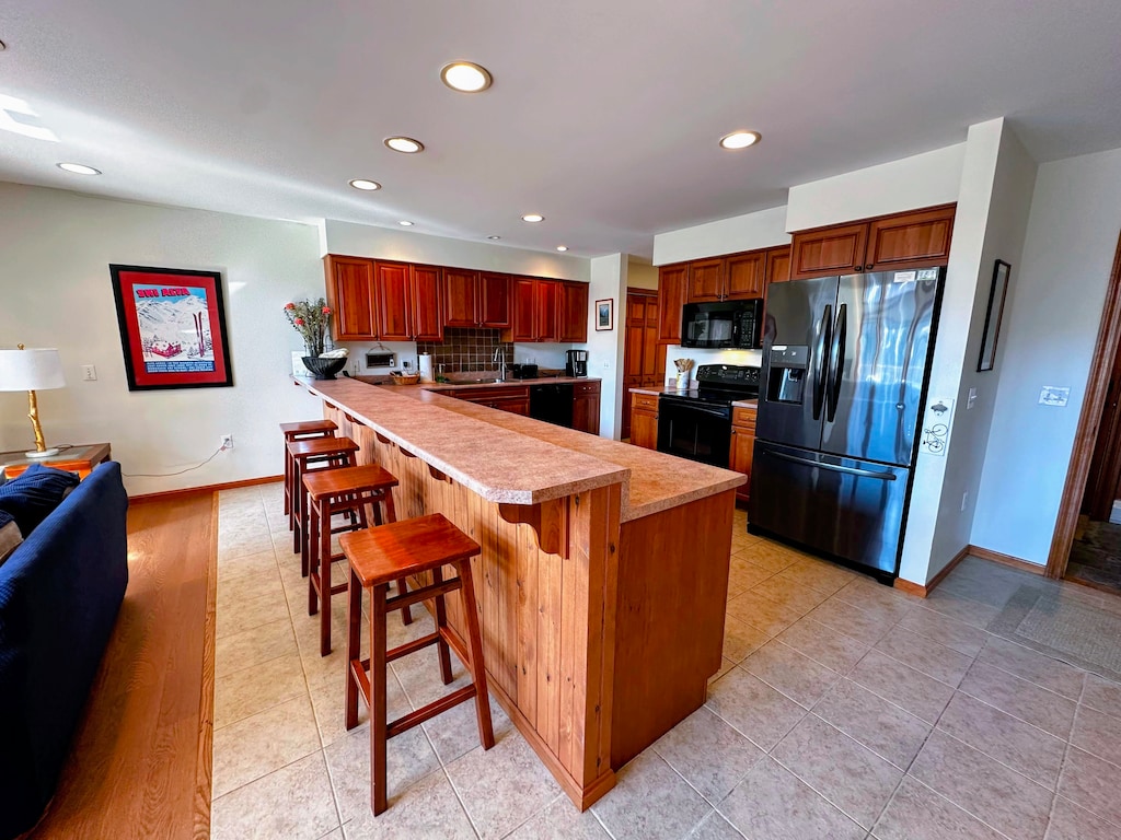 Fully equipped kitchen with modern cabinetry and a breakfast bar,