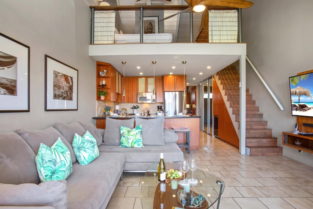 This open-concept living room blends playful coastal touches with lofty elegance and warm island hospitality