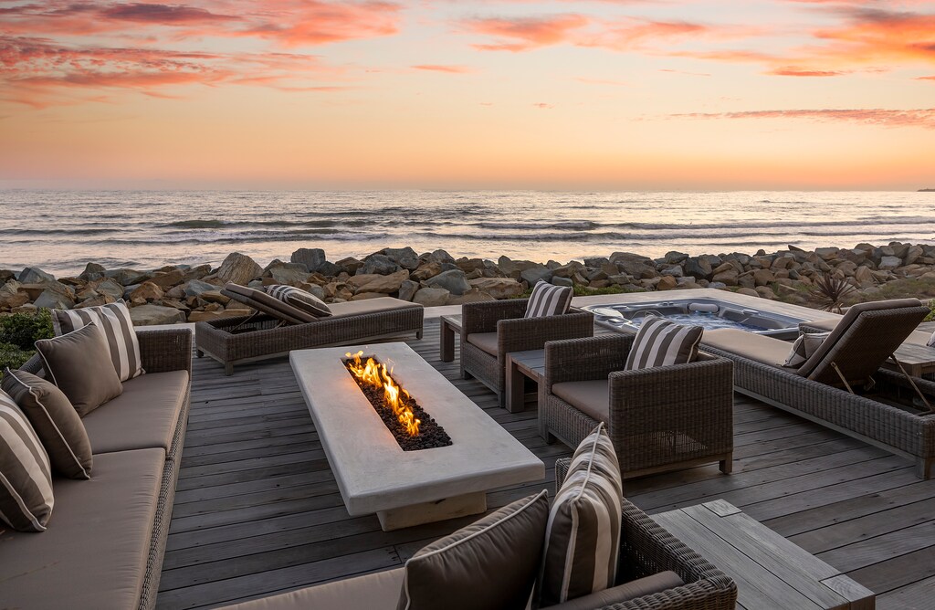 The oversized fire pit is surrounded by ample seating, offering the perfect ambiance to watch the sunset.