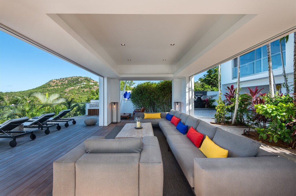 Spacious outdoor living area on the covered patio by the pool, with large and comfy L sofas, facing the panoramic views. Inside lounge area in the great room with the kitchen. 
