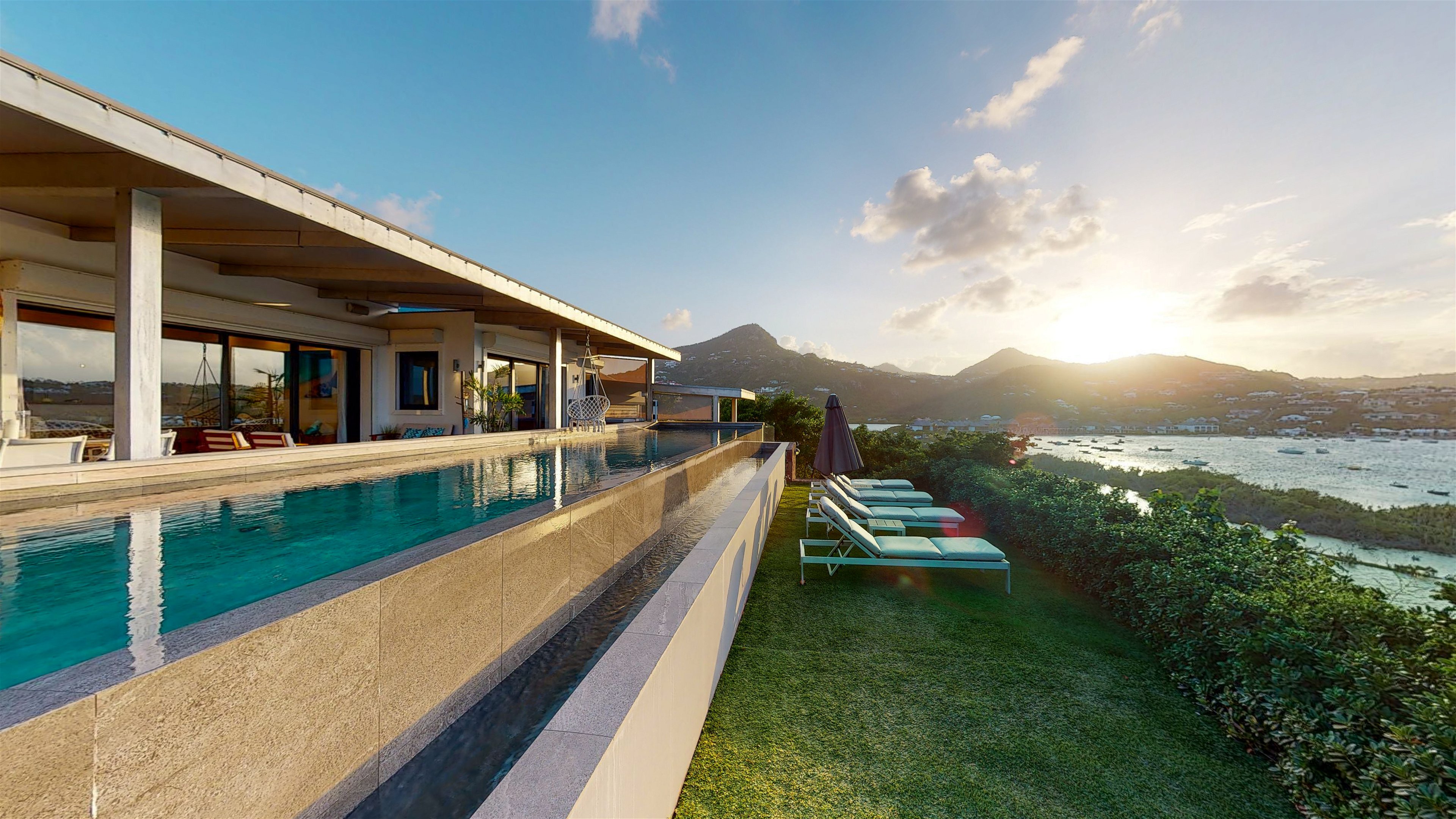 Large heated pool facing the view over the Lagoon. Lounge area  next to the pool. 