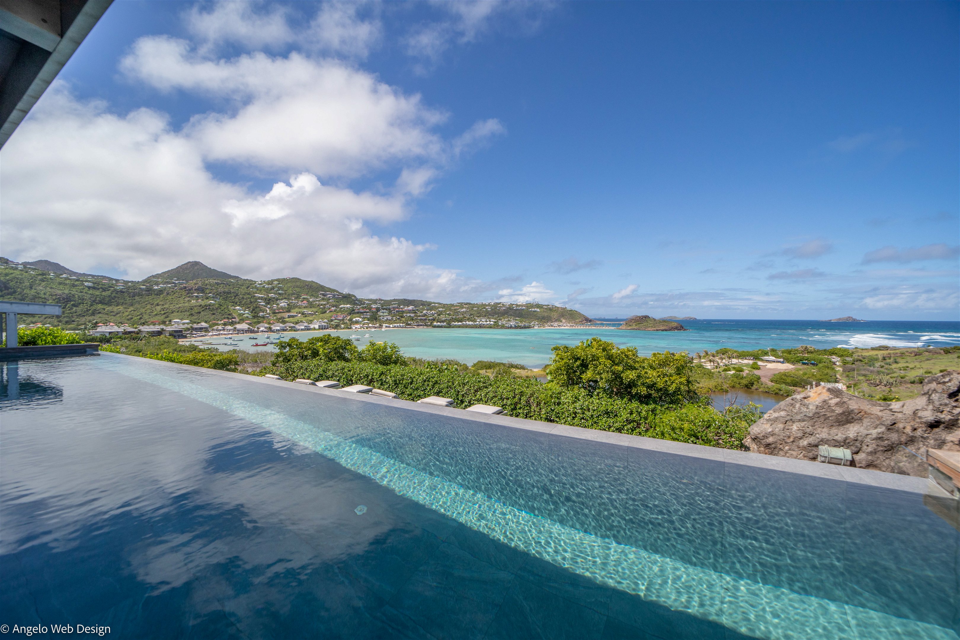 Large heated pool facing the view over the Lagoon. Lounge area  next to the pool. 