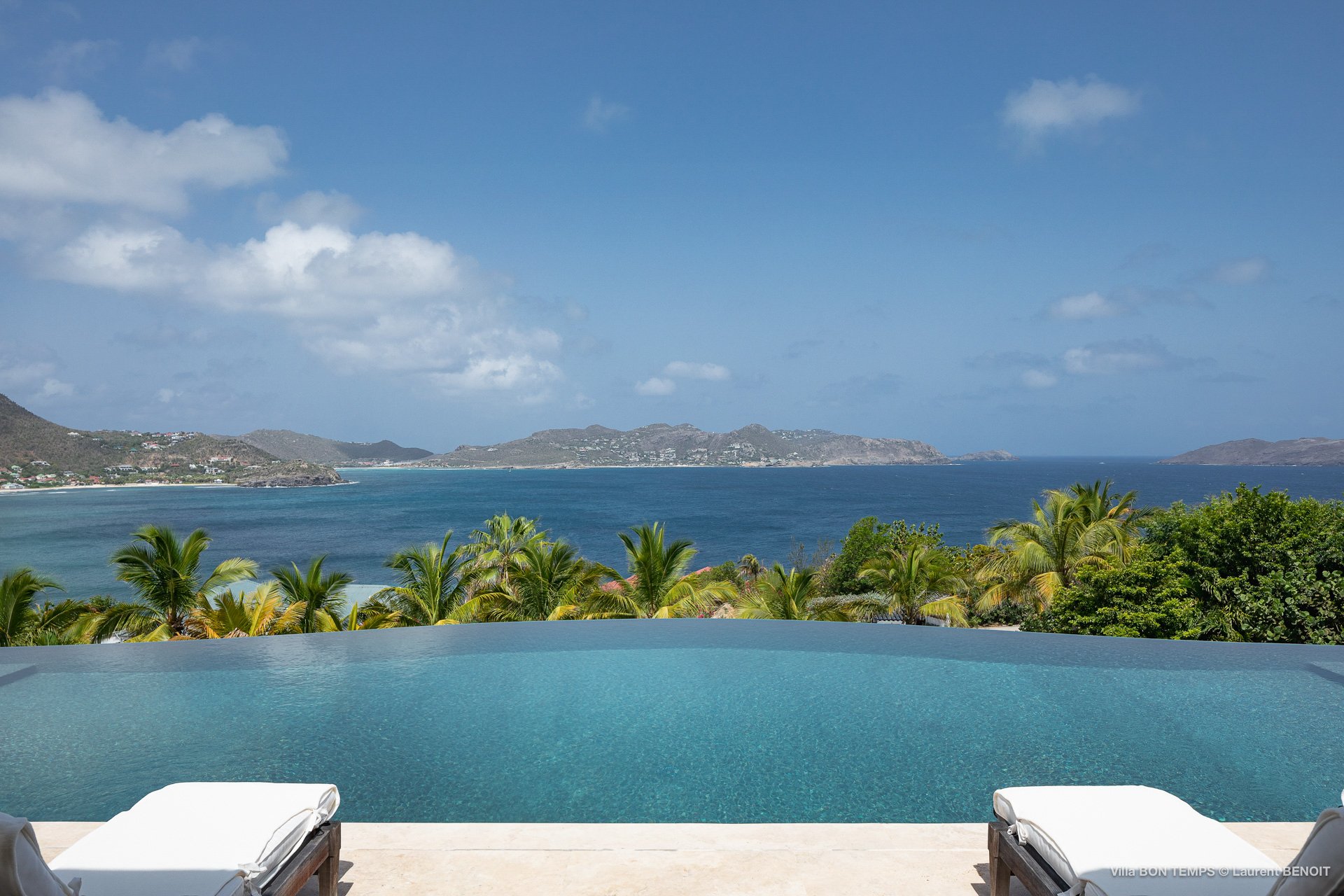 Infinity pool and large covered terrace that runs the length of the villa with dining and lounging areas. 