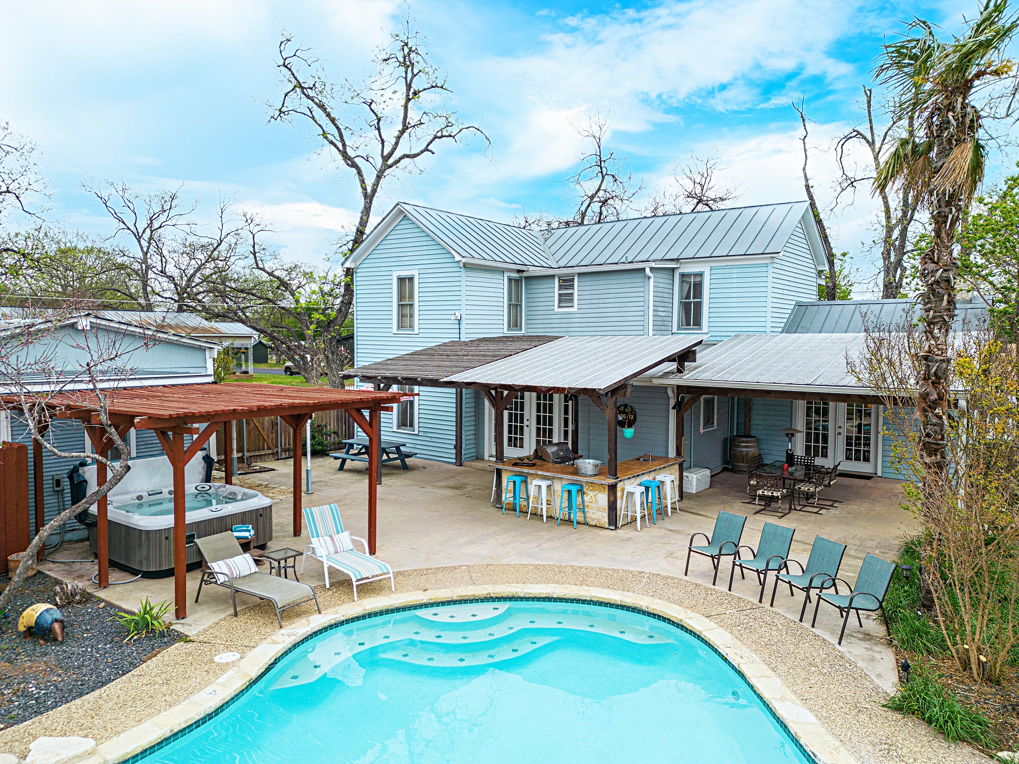 Perfect for entertaining, this backyard oasis features a pool, hot tub, and outdoor dining area with BBQ grill.