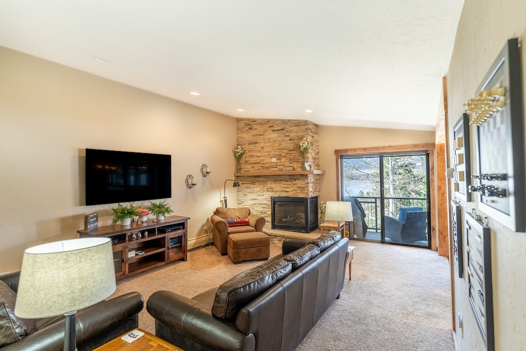 Living area offering a gas fire-place, cozy furnishings and vaulted ceilings.