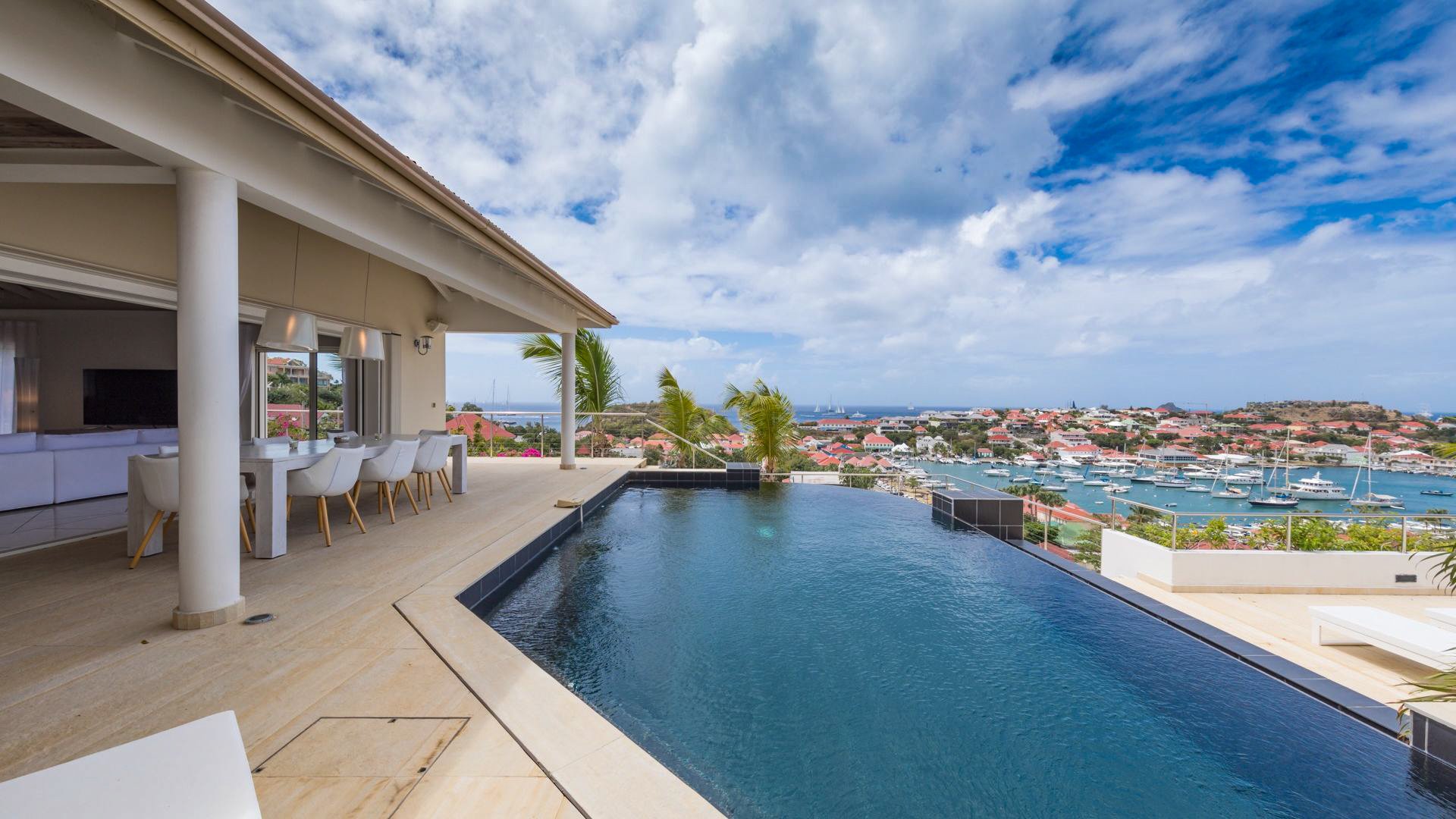 Pool surrounded by a large terrace with lounge chairs, Harbor view.