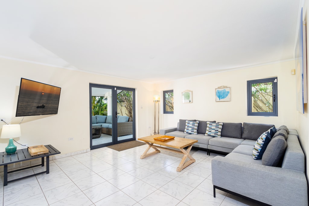 Ostentatious Living Area of the Villa in Noord Aruba - Smart TV and Netflix - Elegant Decor, adding sophistication - Comfy and Cozy Sofas - Spacious living room with glass sliding door access to the backyard