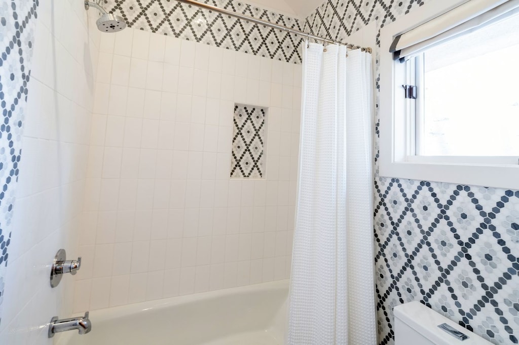 The en suite bathroom from the queen bunk room includes a shower and vanity.
