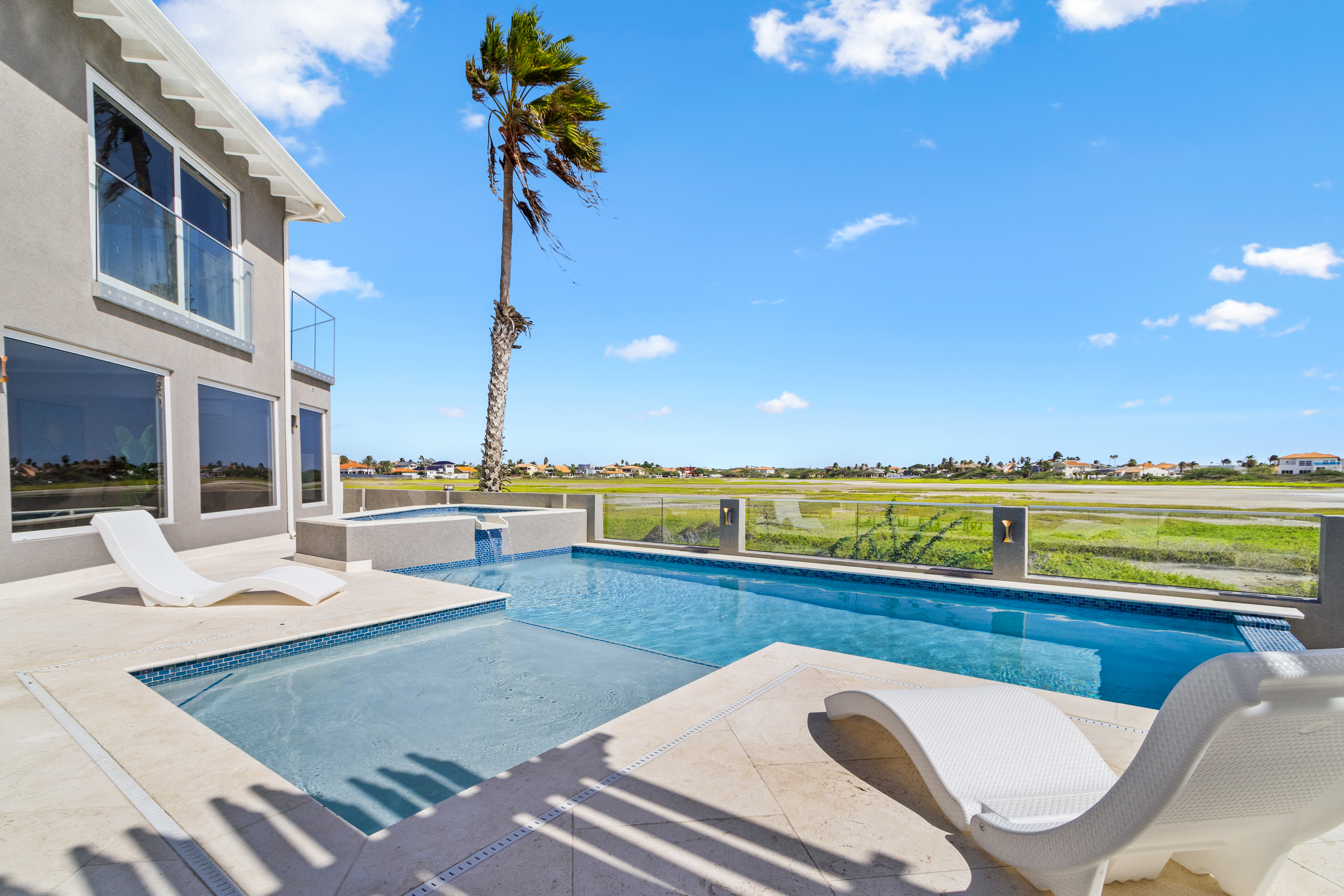Stunning pool with gorgeous Saliña views in Noord Aruba - Provides a relaxed atmosphere for unwinding - Poolside chairs perfect for sunbathing and relaxation - Palm trees and tropical plants enhance the vacation feel