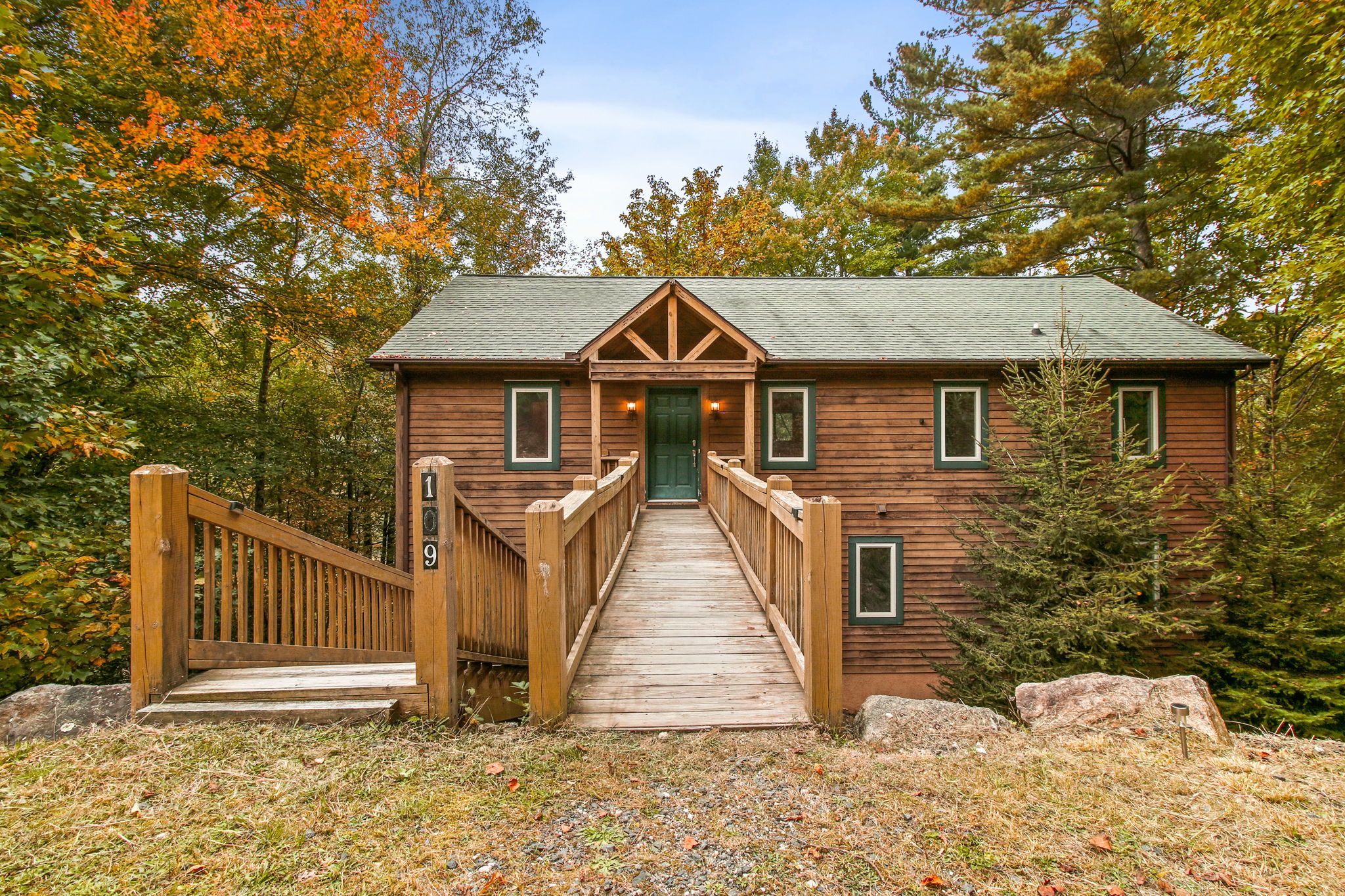 Enter the cabin sanctuary through a charming gateway, where warmth and tranquility welcome you to your haven in the woods.