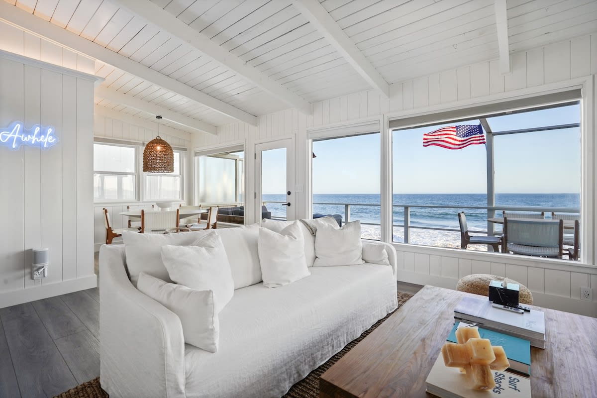 The living Room features a deep pocket white linen seating from Malibu Design Center facing a large Smart TV 
