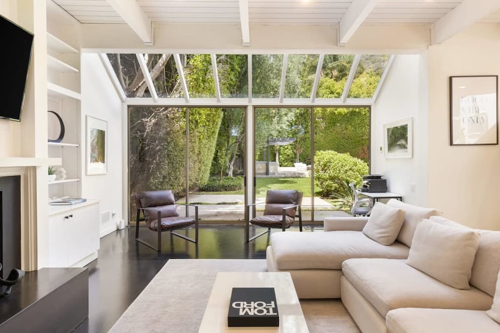 Large floor to ceiling doors that lead to the spacious backyard and BBQ area