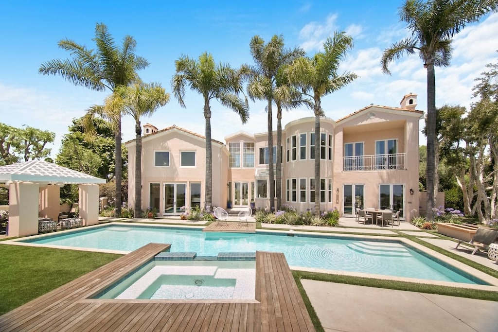 Resort style swimming pool aligned with palm trees.