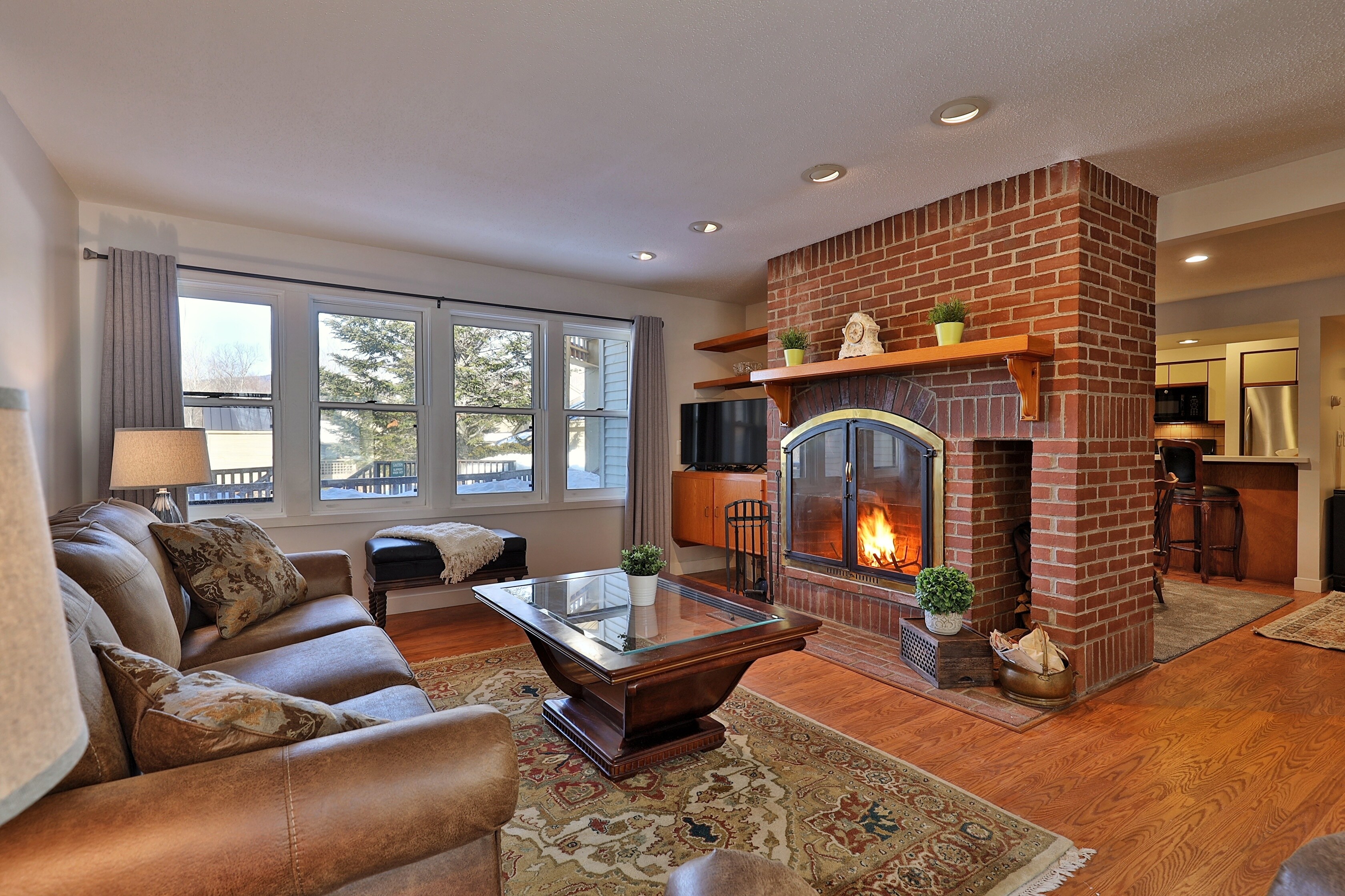 The spacious cozy living room with wood burning fireplace.