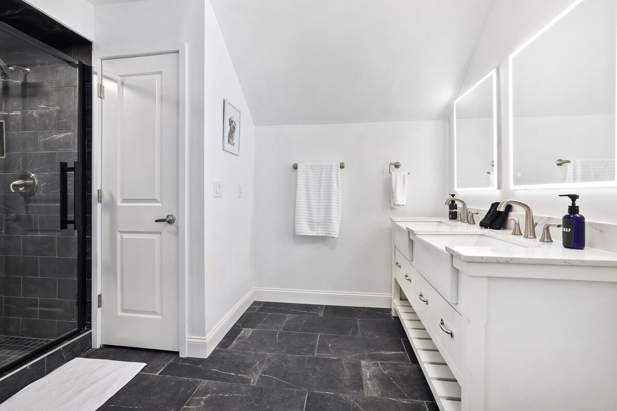 The en suite bathroom has double sinks, a large glass shower and tons of counterspace.