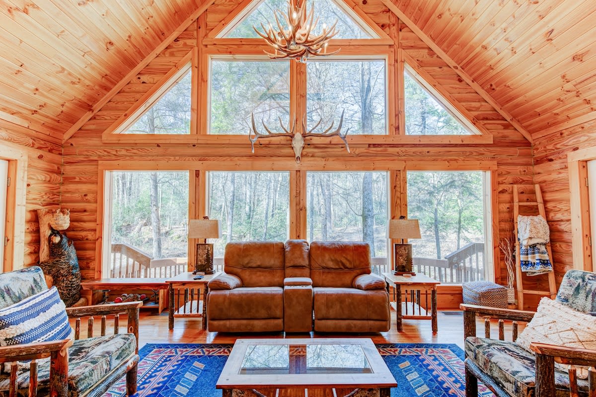 Relax in the beautiful living room with floor to ceiling windows overlooking the creek.