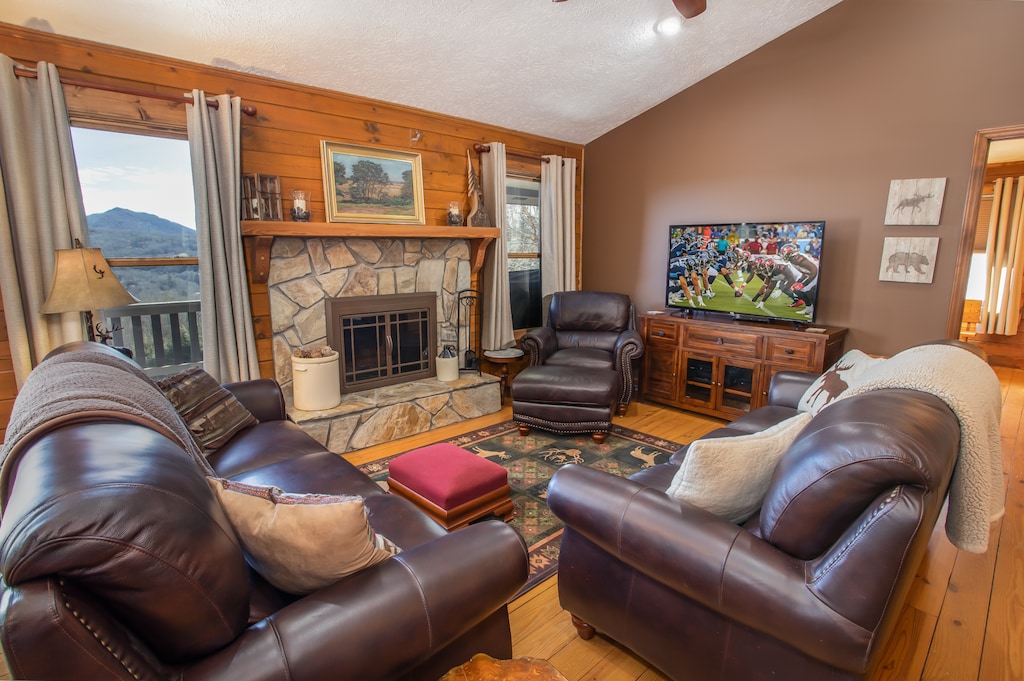 Living Room with HD Smart TV and Wood Burning Fireplace with Flanking View Windows