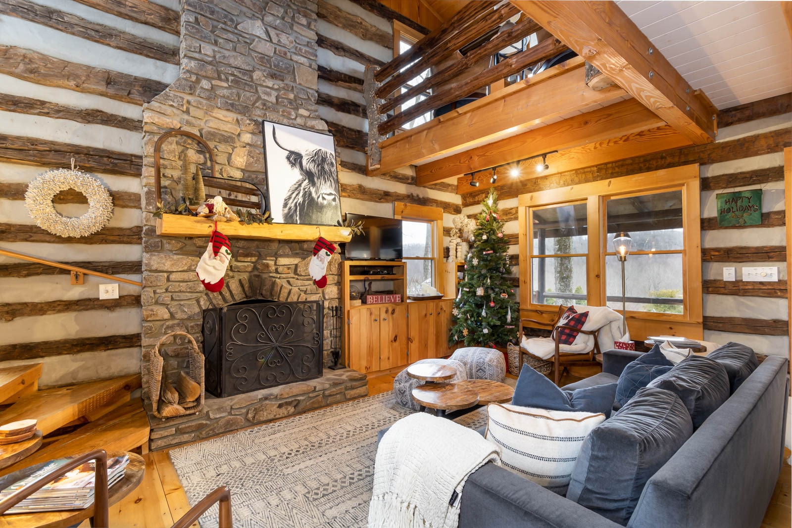 Speckles Great Room with Wood Floors, Rustic Log Walls, and Comfy Furniture