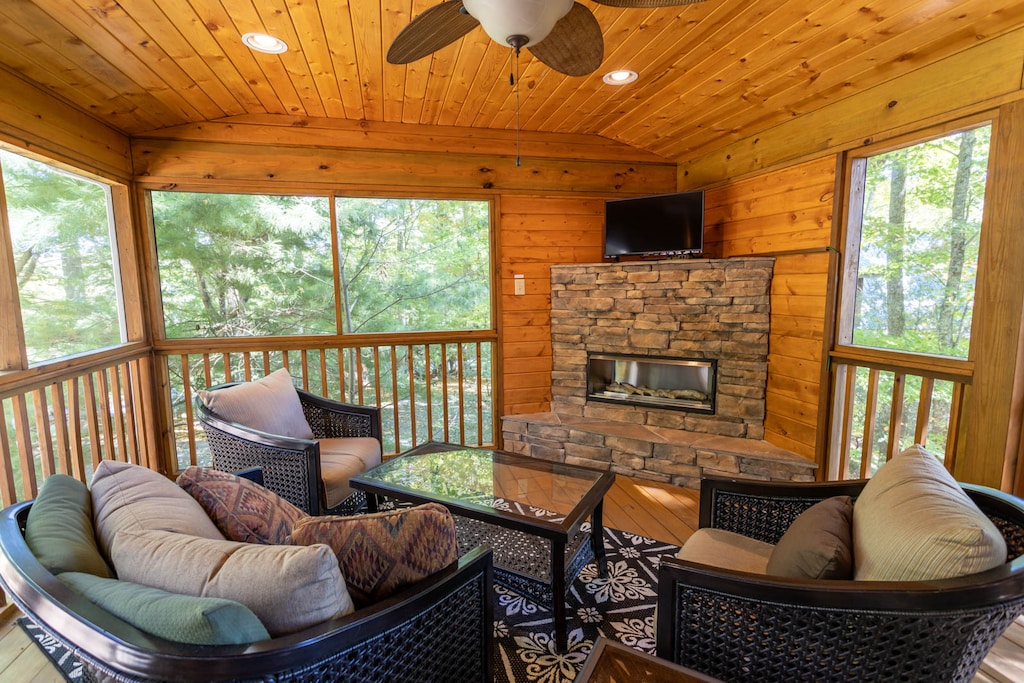 Comfortable Seating Around the Gas Fireplace and TV in the Enclosed and Screened Sun Room Porch
