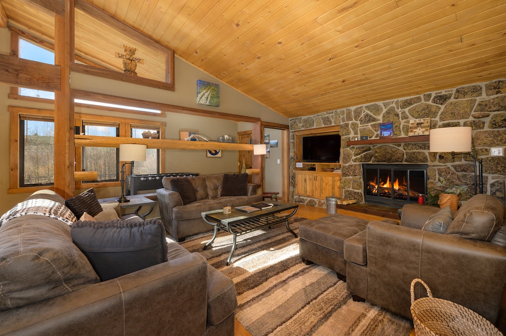 Sink into plush seating beside your crackling stone fireplace, where warm wood beams and mountain views create your perfect retreat.