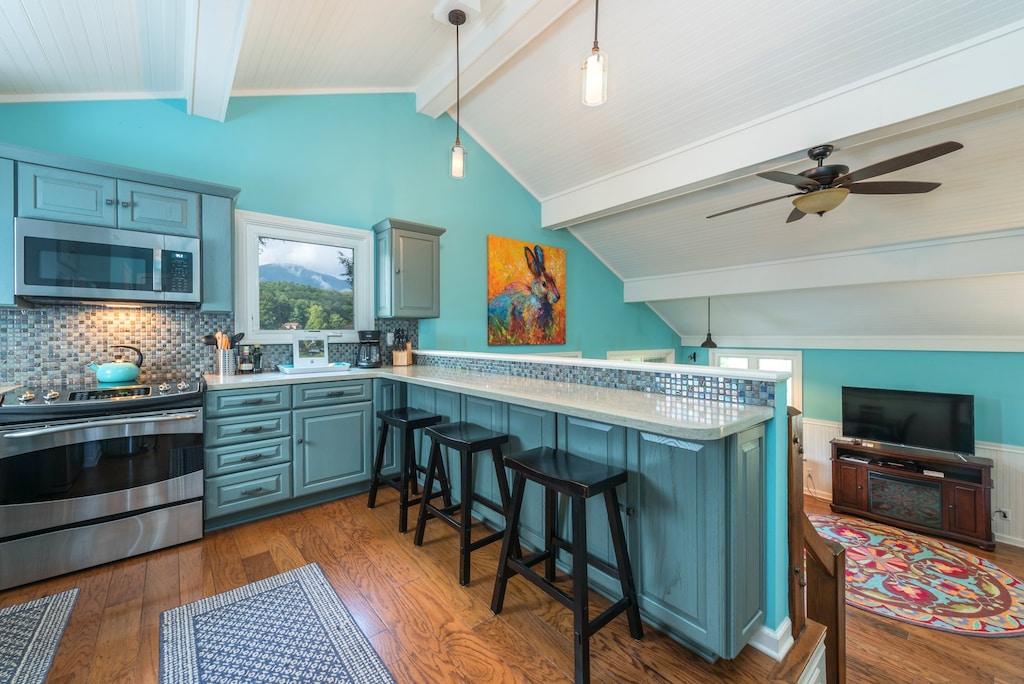 Kitchen with farmhouse sink, dishwasher, bar seating for 3, and standard drip coffeemaker.