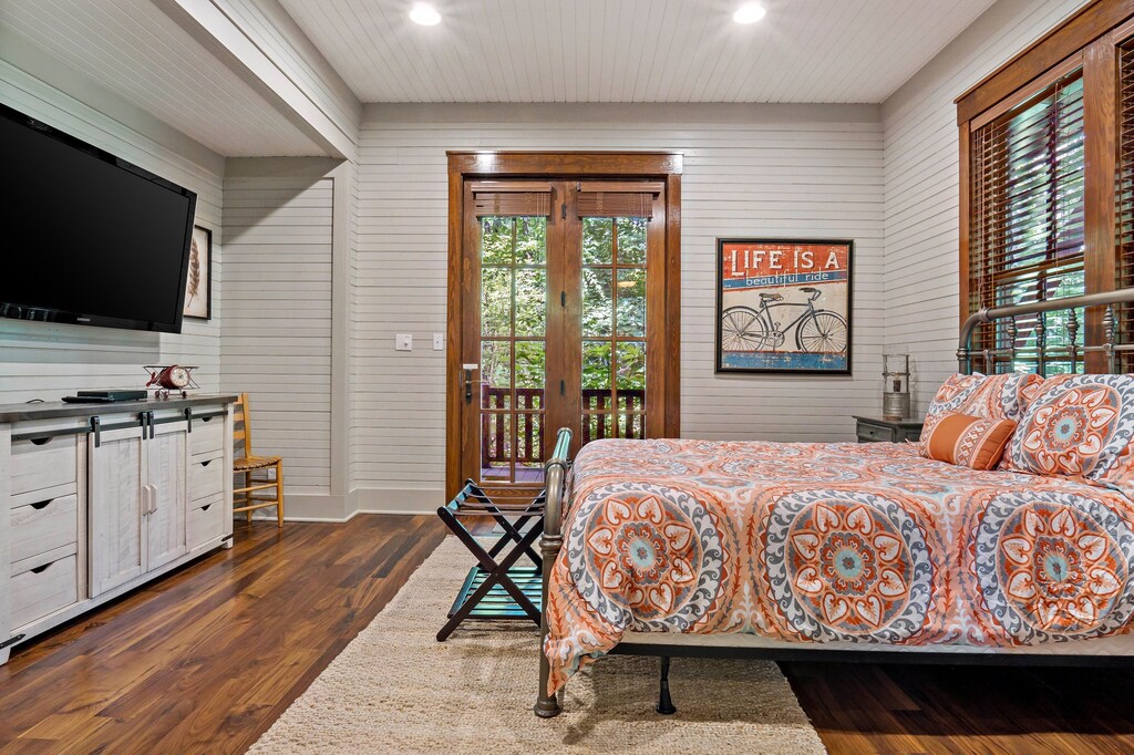 Lower-level bedroom with Queen bed, TV, and deck access.