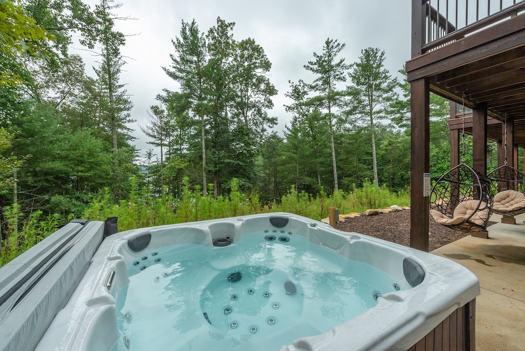 Relax in the outdoor hot tub, situated on the deck, offering a perfect spot to unwind while gazing at the tranquil lake.