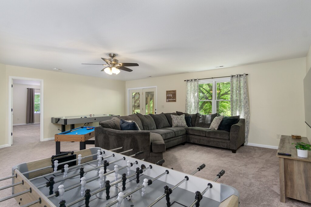 Lower level game room with air hockey, foosball, miniature pool table, and oversized sectional with 65" Roku SmartTV