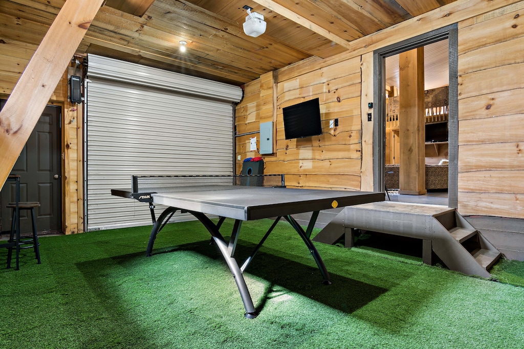 Converted garage game room with ping pong, darts, Connect 4, and cornhole