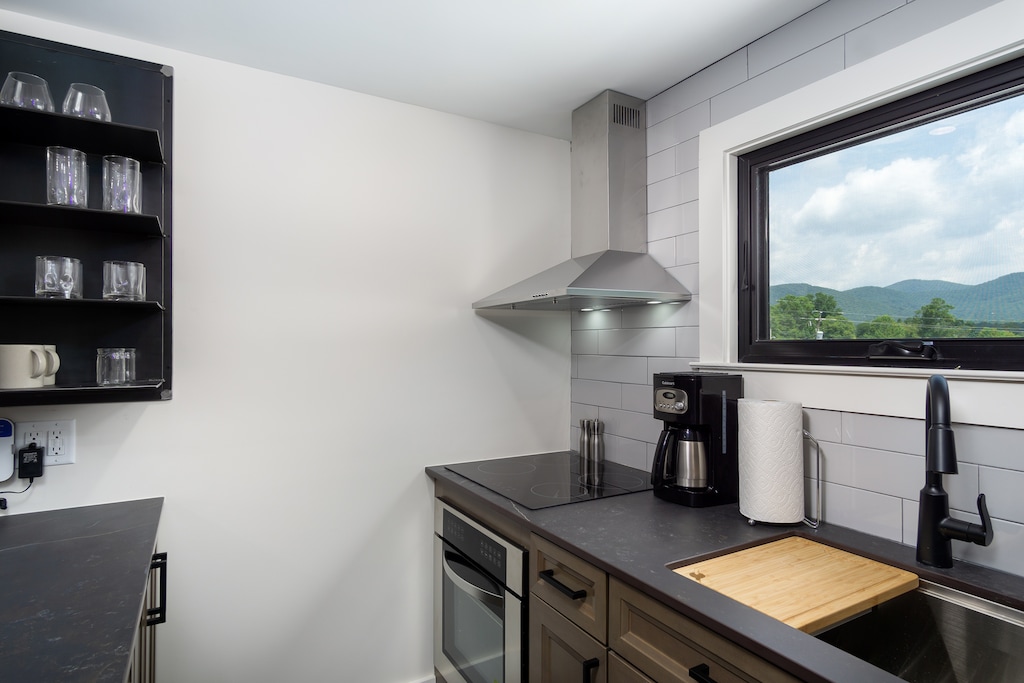 Open-concept kitchen with stainless appliances and breakfast bar seating for 2. Please note: The standard drip-style coffeemaker has been replaced with a Keurig.