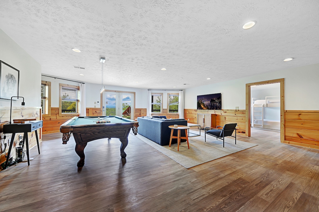 Game room offers a pool table, sitting area with a TV, and outdoor access.