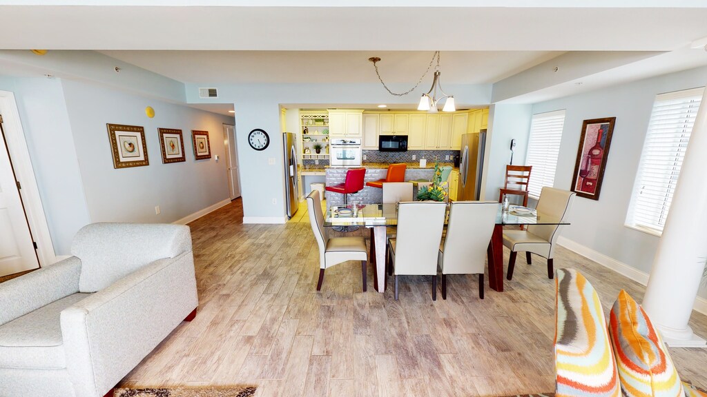 The open floor plan seamlessly connects the fully equipped kitchen, dining space, and inviting living area. Perfect for family gatherings or a cozy night in.