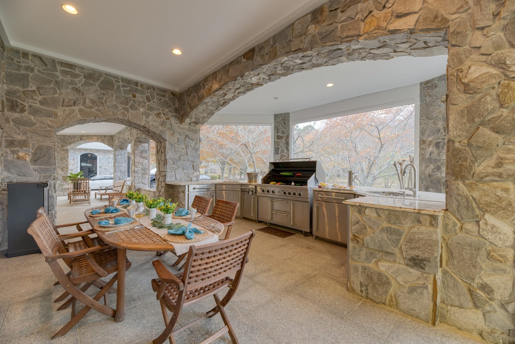 Luxe covered patio with an al fresco dining area, BBQ grill, and prep area.