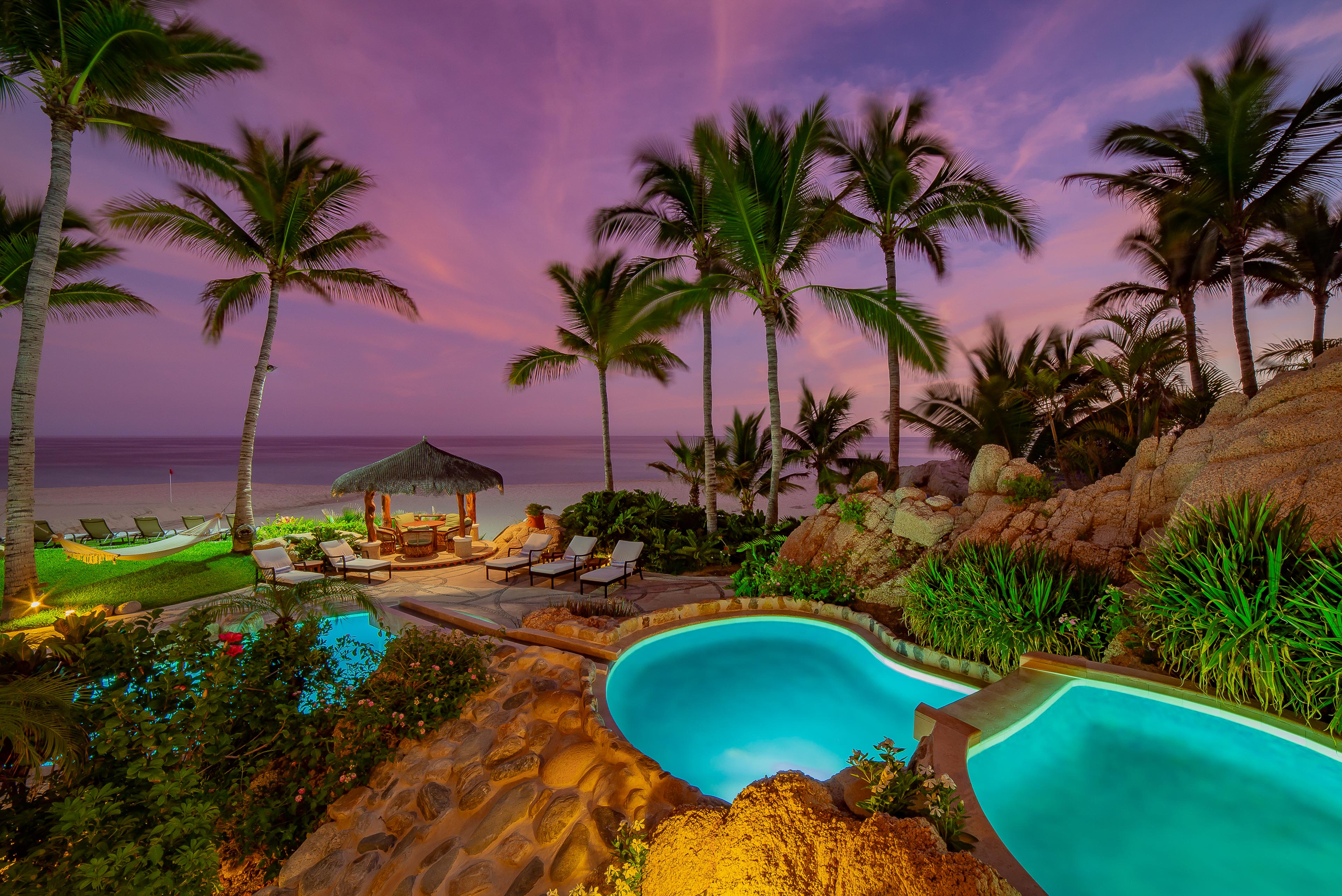 Gorgeous patio with pool and beach view during sunset
