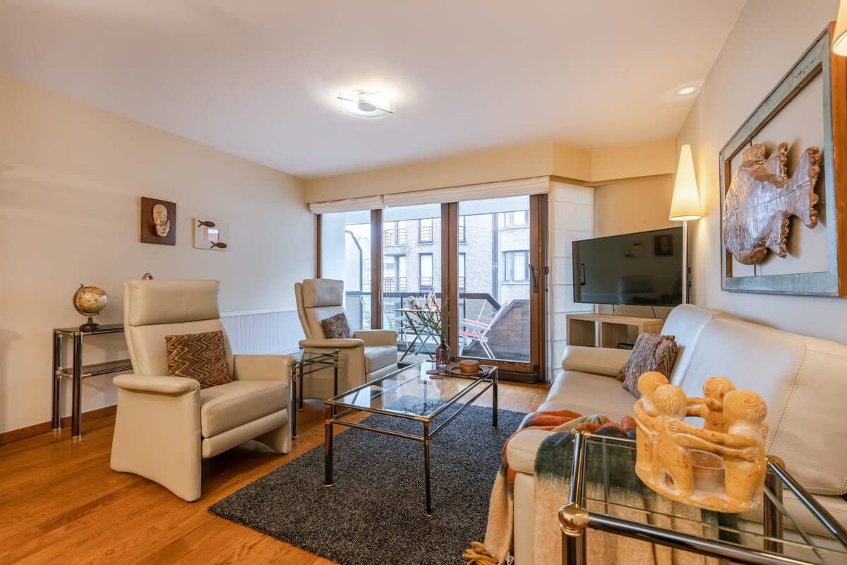 Spacious livingroom with TV and terrace next to it.