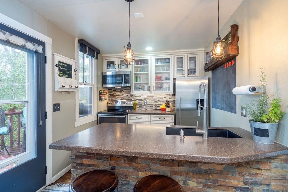 This adorable kitchen and breakfast bar feature a refrigerator, oven, microwave and small dishwasher. Ample counter space for cooking or enjoying après with friends.