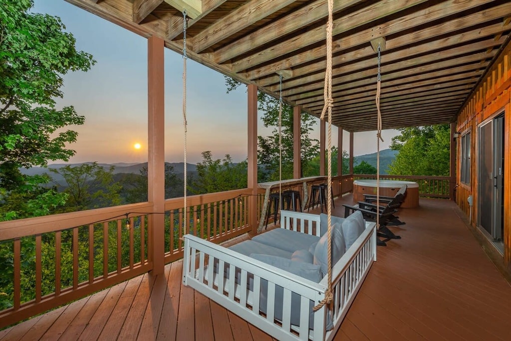 The lower deck is full of space to relax, either in the hot tub or on the swinging day bed!