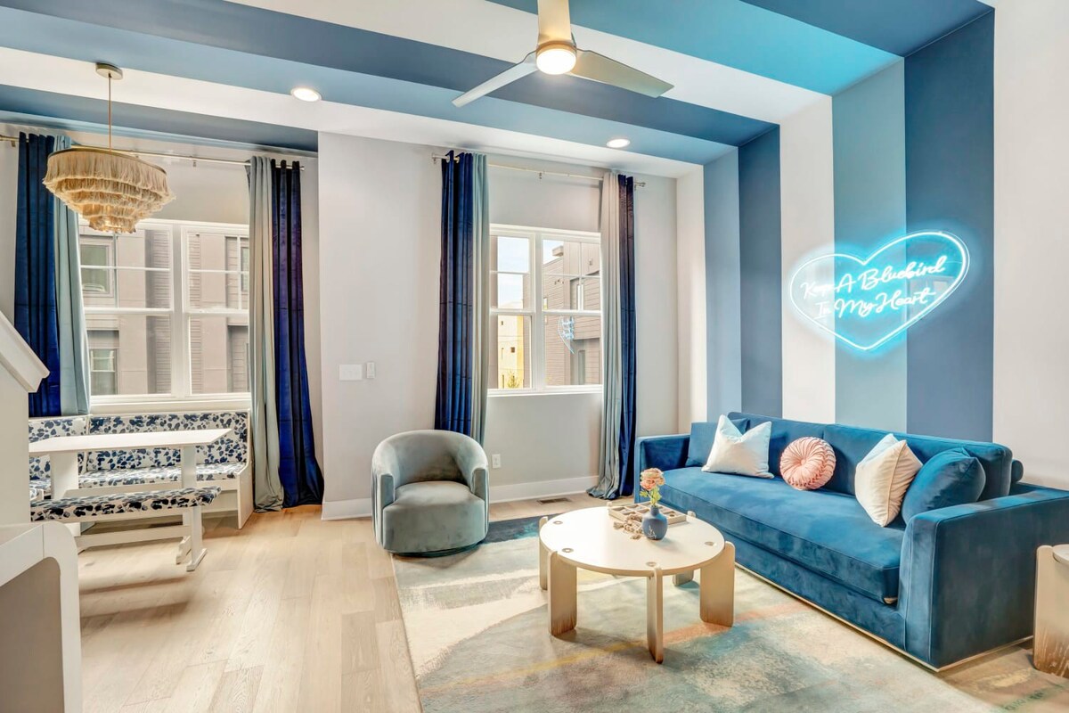 Unwind in elegant comfort within this Nashville luxury vacation rental, perfect for both bachelorette revelries and serene family stays. Nestled under the whimsical glow of the 'A Bluebird In My Heart' neon sign, this chic space embodies Music City's vibrant spirit. Lounge on the plush blue velvet sofa or enjoy the unique window bench—ideal nooks for sipping morning coffee or evening cocktails. With a striking blue and white motif, accented by playful patterns and modern decor, every corner promises a photo-op worth remembering. 

Book your stay at Misfit Homes today!
