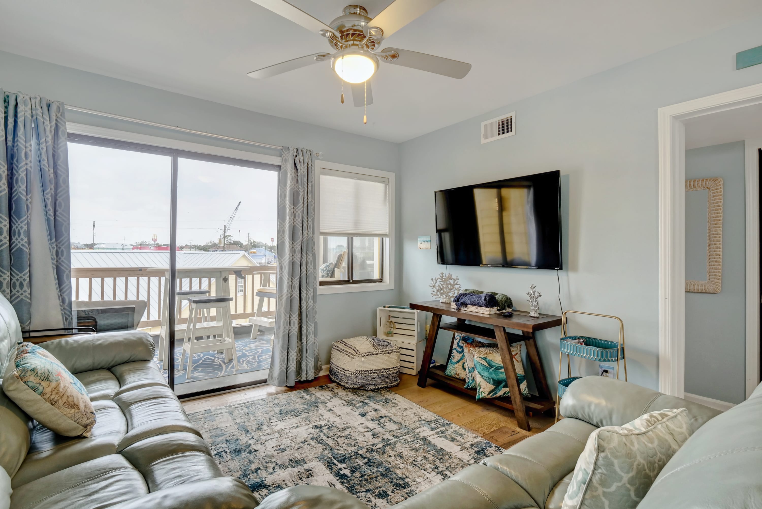 A neatly arranged living room, with a view extending to the balcony.