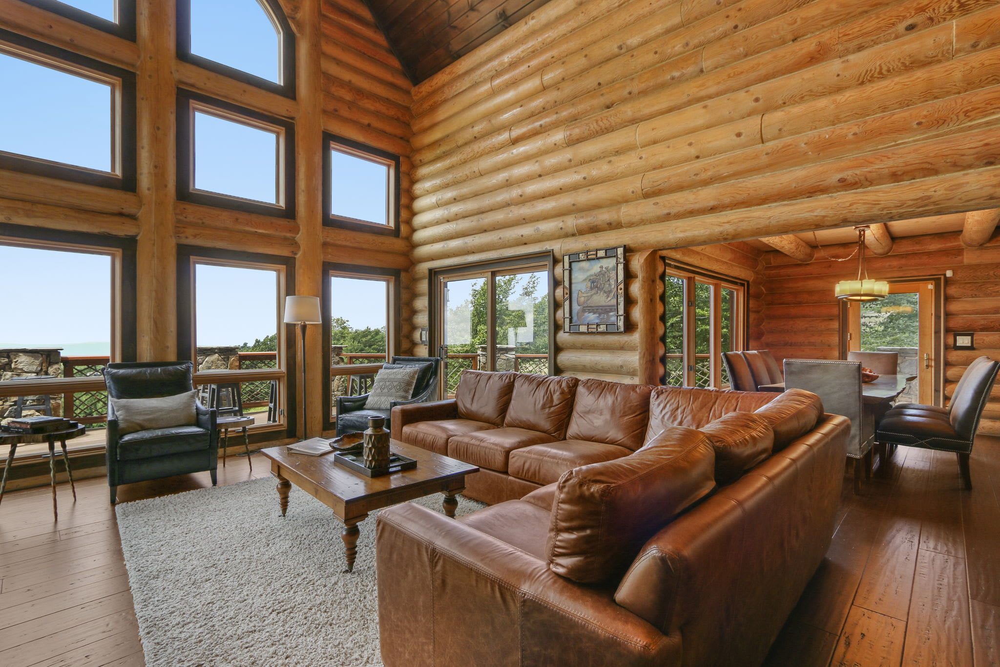 Indulge in living room comfort with a plush couch and chairs surrounding the gas fireplace. Perfect for unwinding after a day of adventure, set against a scenic backdrop of nature's beauty.