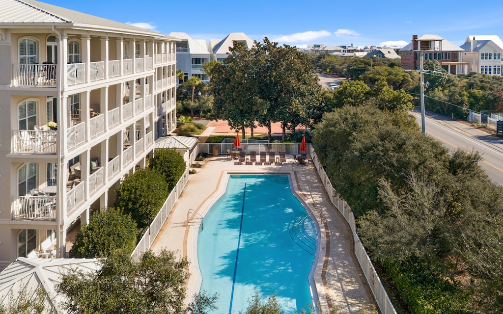 Aerial view of the property showcasing the swimming pool area and surrounding residential neighborhood with coastal architecture.