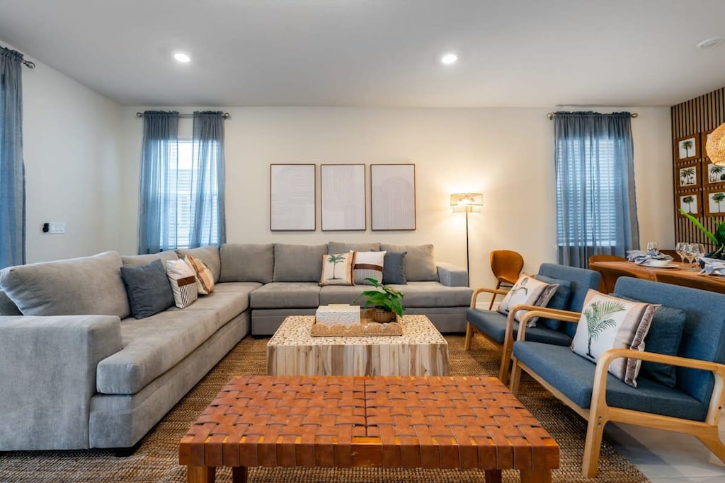 Relax in this stylish living room with a cozy sectional, chic decor, and abundant natural light—perfect for unwinding after a day of adventure.
